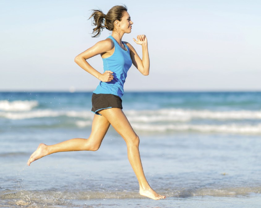 Photo d'une runneuse pieds nus le long de la mer