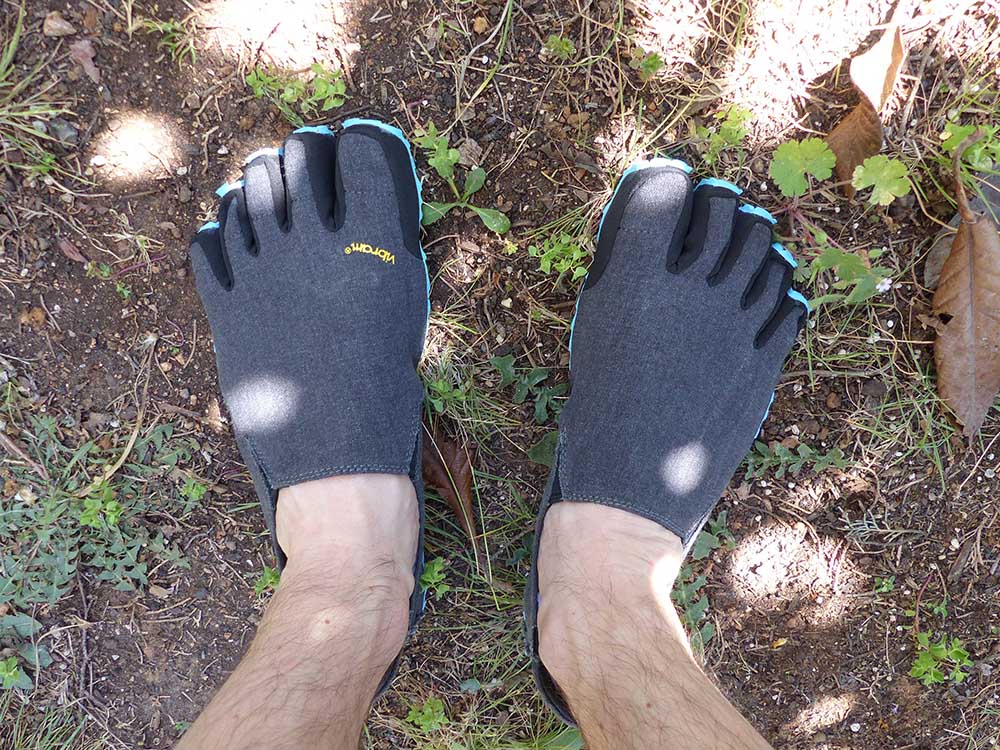 Photo vu de dessus des chaussures minimalistes Vibram fivefingers portées pieds-nus.